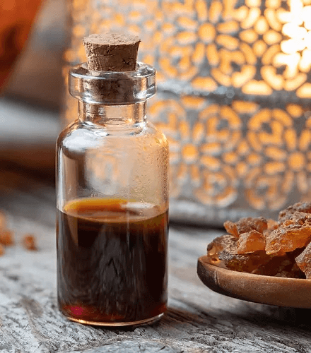 Glass bottle of luxurious frankincense oil beside resin pieces, emphasizing organic anti-aging skincare.